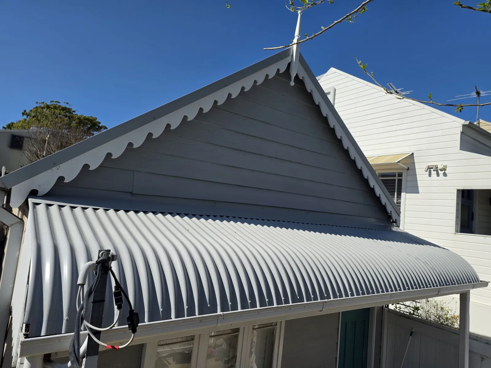 Custom-curved Blue Orb awning and completed metal roof at the front gable of the View Street, Annandale miner's cottage