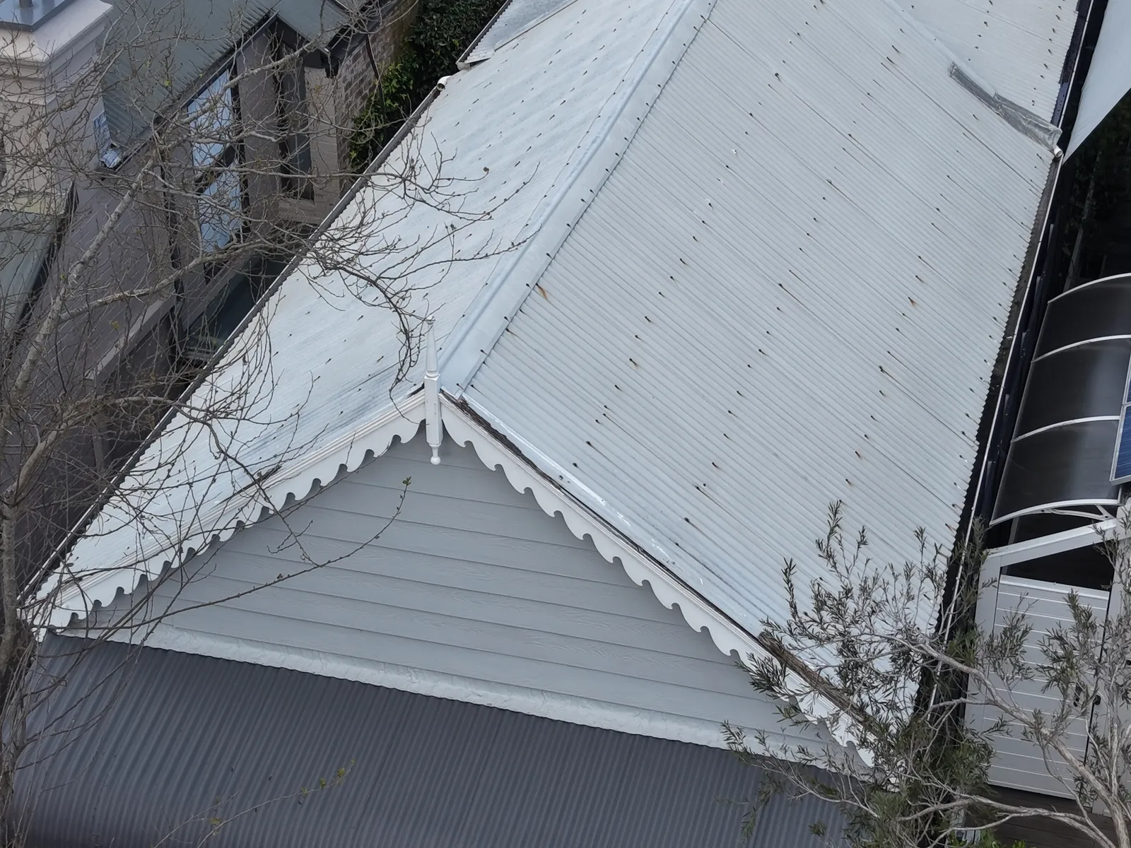 Weathered Zincalume roof and decorative gable on the miner's cottage at View Street, Annandale before replacement