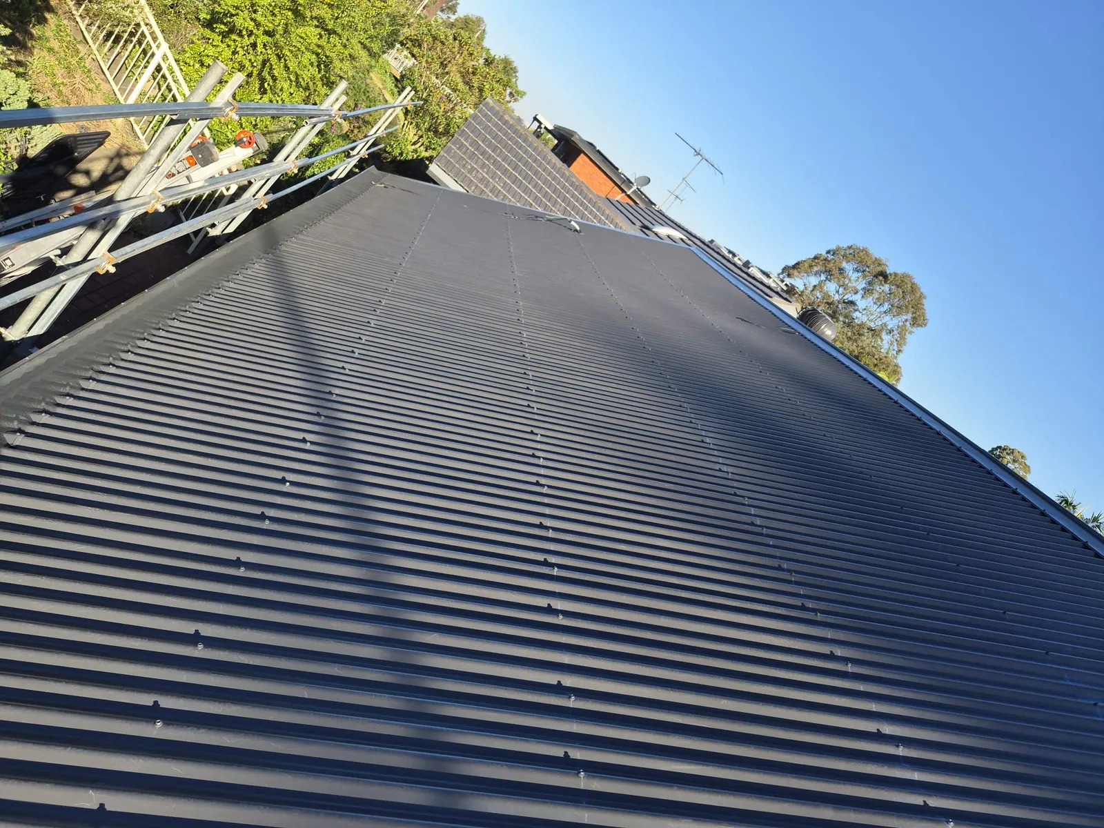 View along the new corrugated metal roofing toward the roof edge at Eagle Street, Ryde
