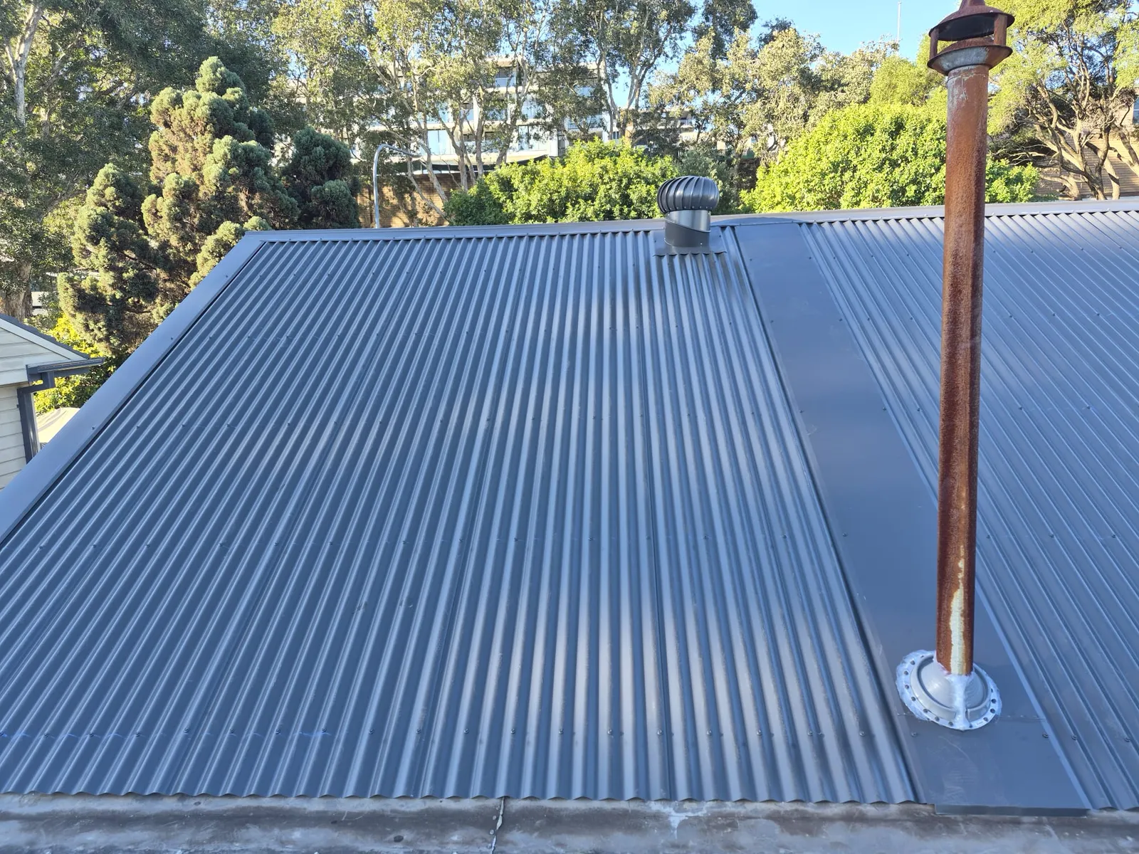 New corrugated roof with finished flashings around the existing roof penetrations on the Ryde home