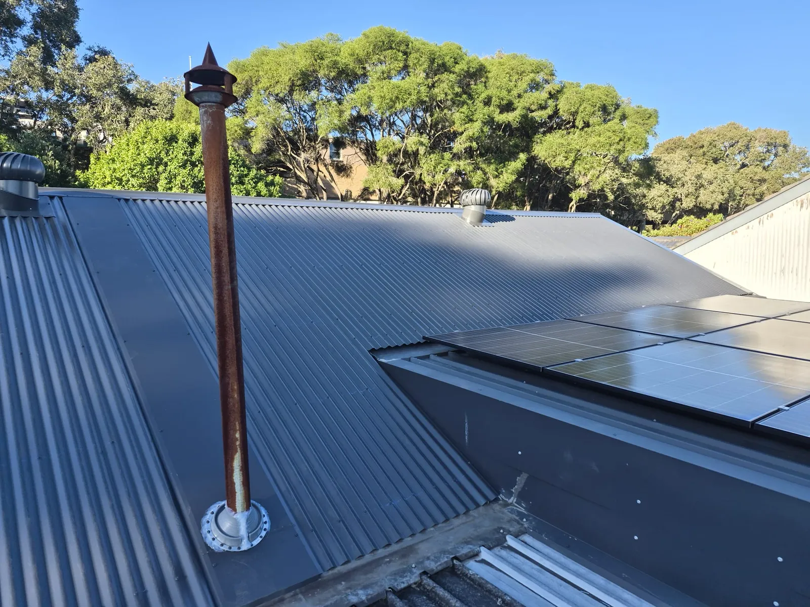 Finished metal roofing and flashing details beside the solar panels at Eagle Street, Ryde