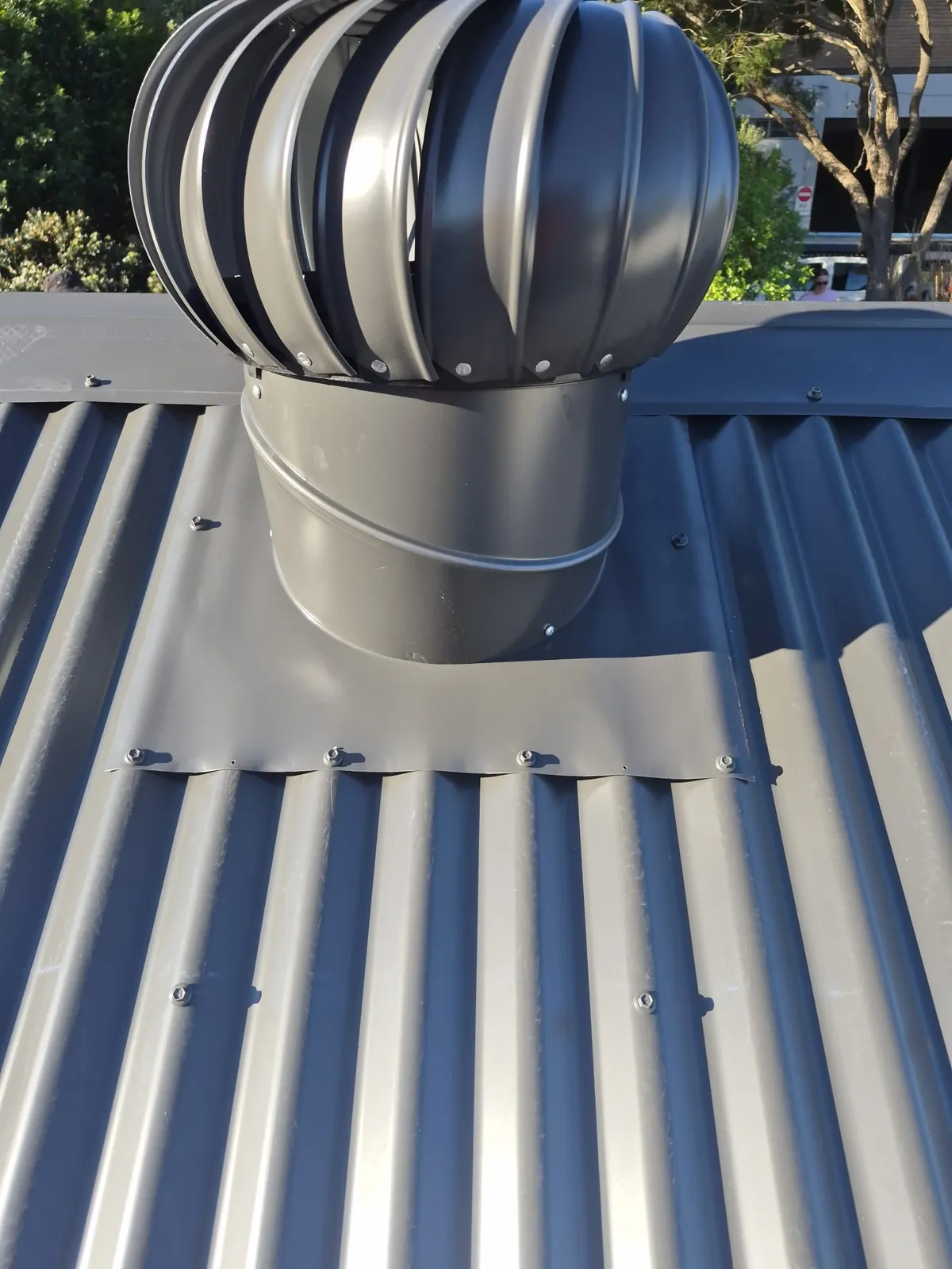 Roof ventilator and its finished flashing on the new corrugated metal roof at Eagle Street, Ryde
