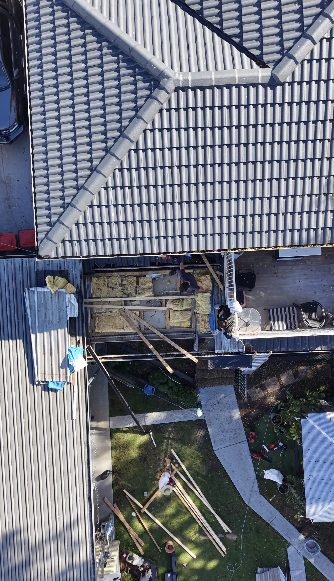 Aerial view of a Sydney roof mid-replacement — tiles stripped, Colorbond going on